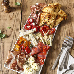 Grand assortiment d’antipasti : charcuteries et fromages italiens, légumes et pains Del Arte