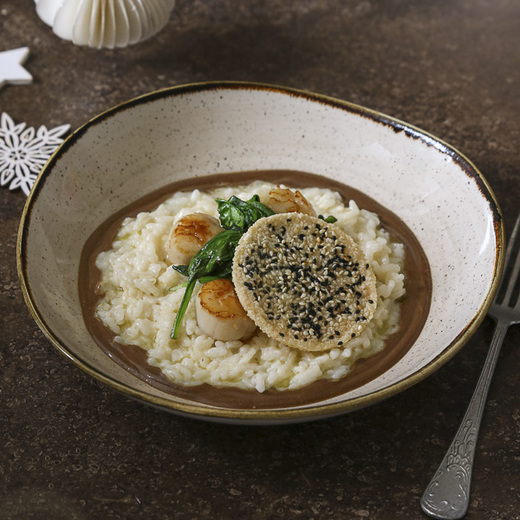 Risotto crémeux, crème d'ail noir, noix de Saint-Jacques, pousses d'épinard, tuile de fromage italien râpé et graines de sésame
