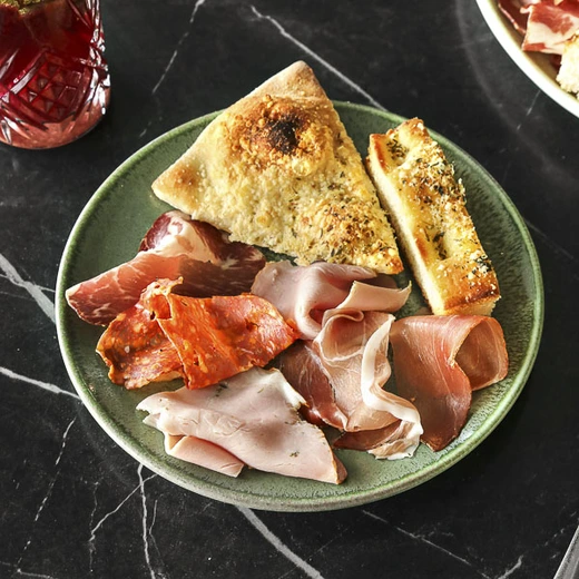 Jambon speck, coppa, jambon aux herbes, spianata. Servie avec du pain focaccia et pain Del Arte Jambon speck, coppa, jambon aux herbes, spianata. Servie avec du pain focaccia et pain Del Arte
