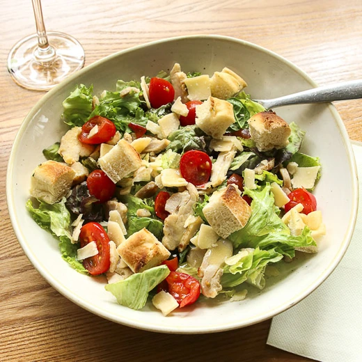 Emincés de poulet, tomates cerises, croûtons de pain focaccia, copeaux de fromage italien, salade Emincés de poulet, tomates cerises, croûtons de pain focaccia, copeaux de fromage italien, salade