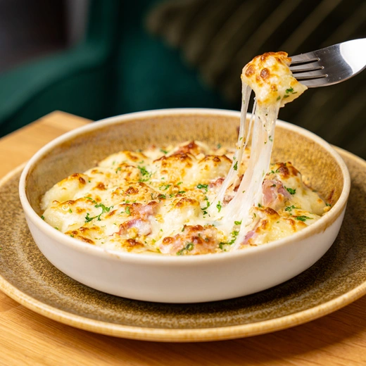 Gnocchi fourrés au gorgonzola, crème, jambon speck, gratinés à la mozzarella, crumble au fromage Gnocchi fourrés au gorgonzola, crème, jambon speck, gratinés à la mozzarella, crumble au fromage