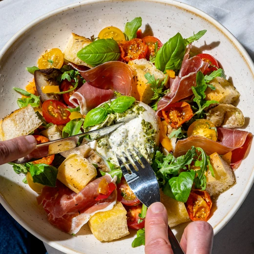 Burrata, jambon de Parme, poivrons grillés, aubergines grillées, tomates cerises, croûtons de pain focaccia, pesto vert, roquette Burrata, jambon de Parme, poivrons grillés, aubergines grillées, tomates cerises, croûtons de pain focaccia, pesto vert, roquette